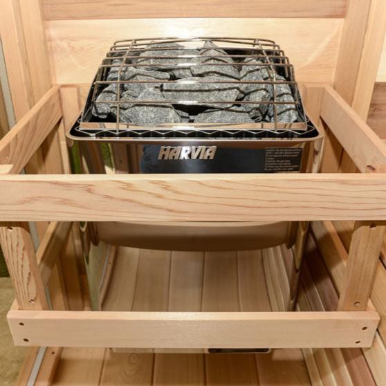 Front view of a sauna heater filled with rocks, designed to generate heat for sauna rooms.