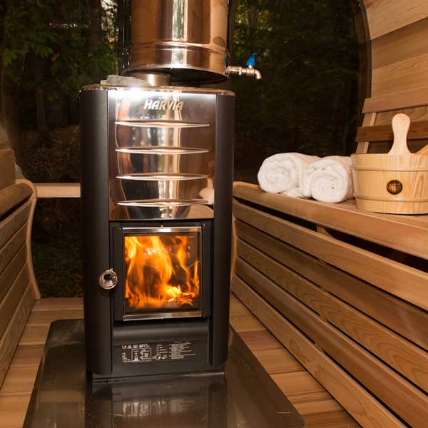 A wood burning sauna heater viewed from a slightly bottom-up angle, showcasing its sleek design and burning flames inside.