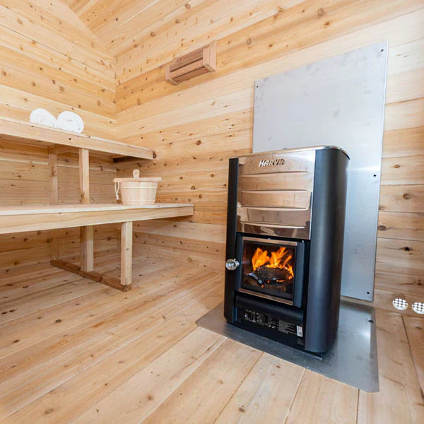 Interior view of a Georgian cabin sauna featuring a sauna heater and cozy benches.