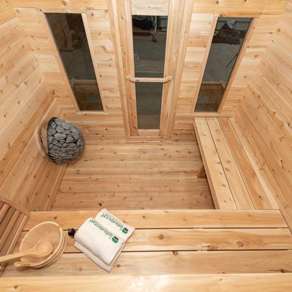 Interior view of a Georgian cabin sauna showcasing stone accents and wooden benches.