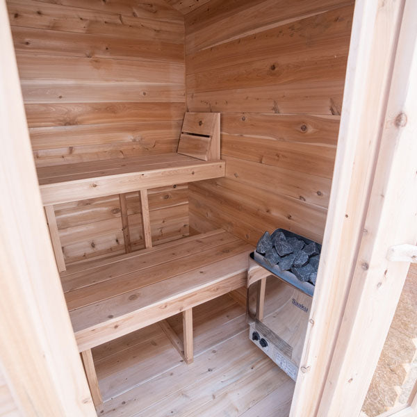View from the door of the Granby Cabin Sauna, featuring a sauna heater and two benches.