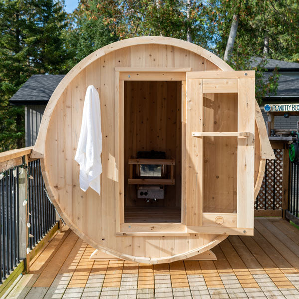 Front view of a Harmony Barrel Sauna with the door open, revealing the sauna heater inside.