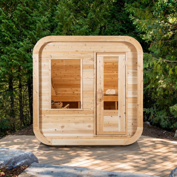 Front view of the Luna Electric Heated Sauna CTC22LU, surrounded by lush trees.