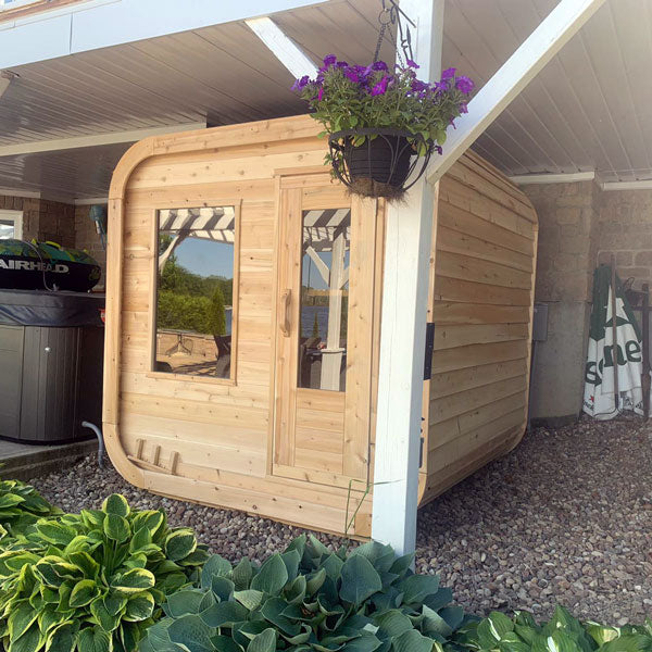 Front view of a Canadian Timber Luna Sauna with a glass window and door, seen from underneath the ceiling.