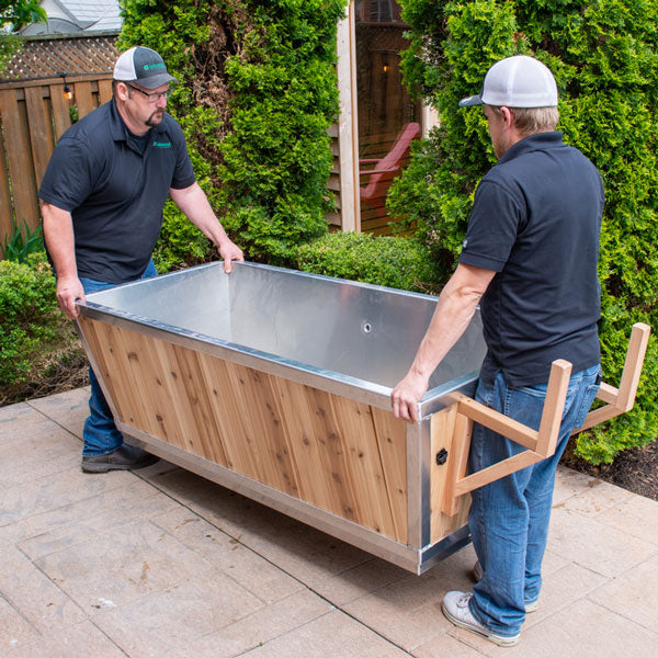 Polar Plunge Tub in an open position while being lifted for arrangement by technicians, showcasing its functionality and design.