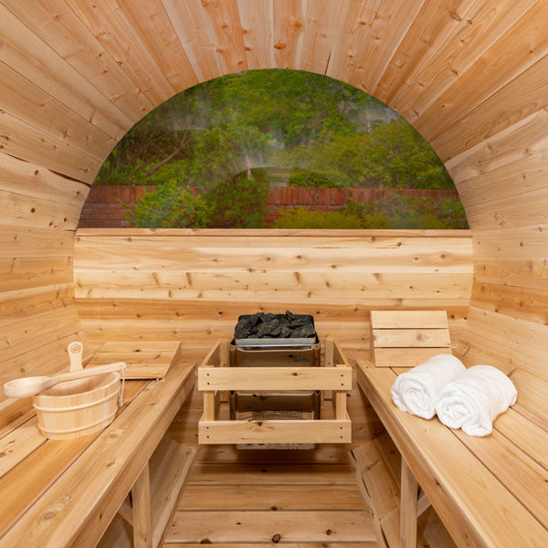 Back view of the Tranquility MP Barrel Sauna featuring half-moon glass, two benches, and a sauna heater in the center.