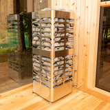 Front and side view of the Homecraft Revive 7.5kW electric sauna heater positioned near a glass wall and a wooden wall.