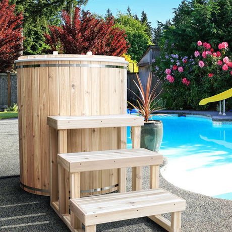 Baltic Cold Plunge Tub with front stairs placed by the pool, showcasing its sleek design and inviting setting.