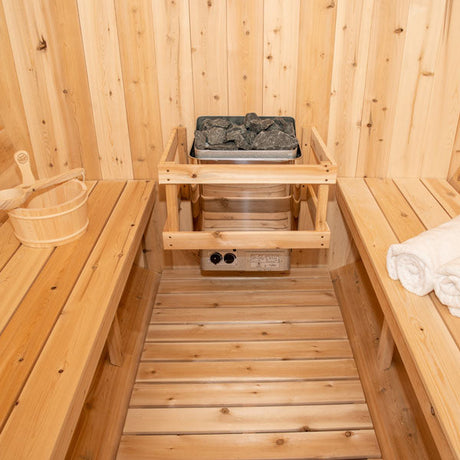 Inside view of a Harmony Barrel Sauna featuring a sauna heater and two benches.