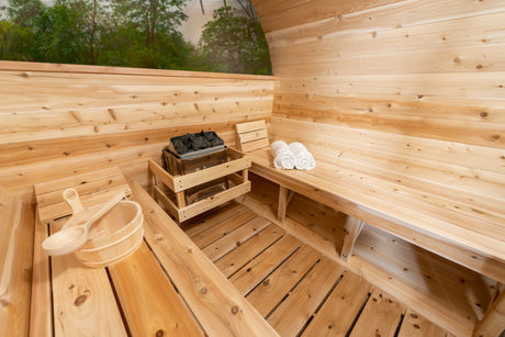 nside semi-left side angle view of the Serenity MP Barrel Sauna, showcasing a sauna heater at the center, two benches on each side, and a half-moon glass window at the back.