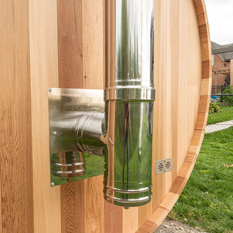 A close-up view of a chimney and heat shield set, showcasing the detailed construction and materials used. The heat shield is positioned around the chimney, emphasizing its protective features and design.