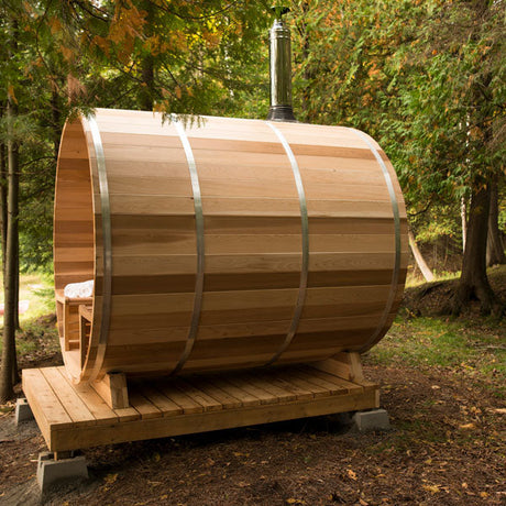 A top chimney and heat shield set with a water tank, viewed from a distance against a full back wall, showcasing the complete setup in an outdoor environment.